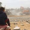 A child watches as bodies are recovered from under the rubble of a house in the Al-Nasr neighborhood, east of the city of Rafah, in the southern Gaza Strip.