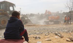 A child follows/watches the recovering of bodies from under the rubble of a house in the Al-Nasr neighborhood, east of the city of Rafah, in the southern Gaza Strip.