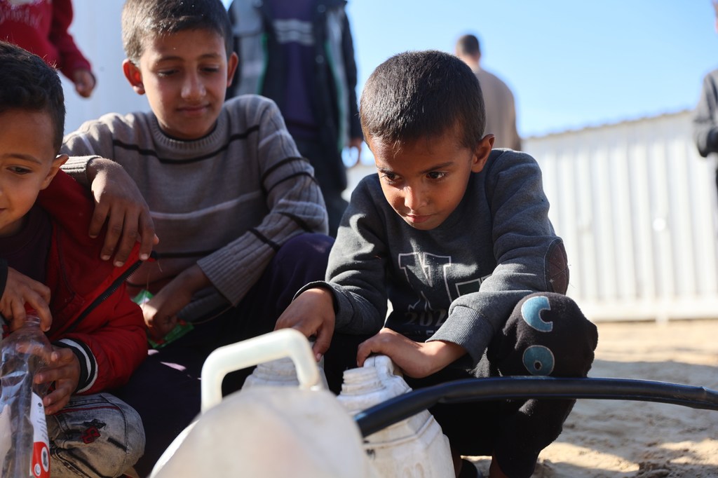 Children fill containers with drinking water in the Al-Shaboura neighborhood in Rafah, southern Gaza.