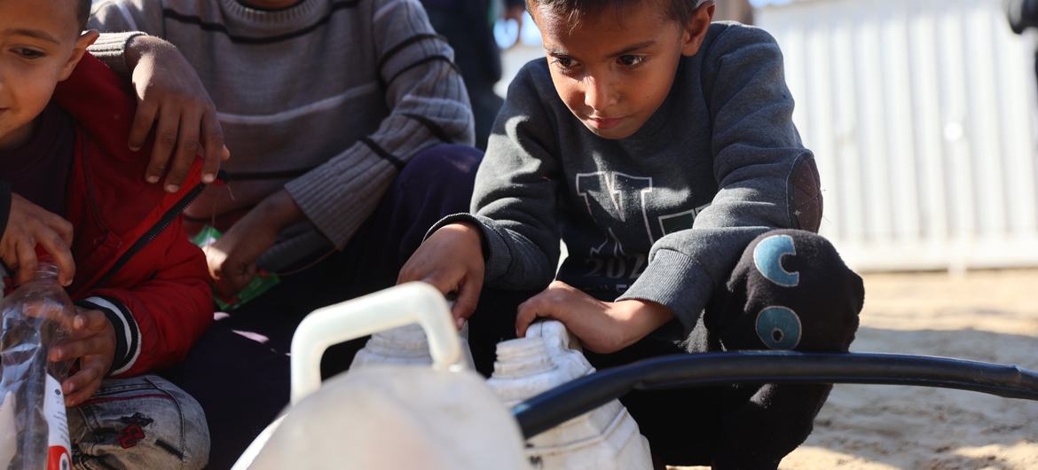 Unos niños llenan contenedores de agua potable en el barrio de Al-Shaboura, en Rafah, al sur de Gaza.