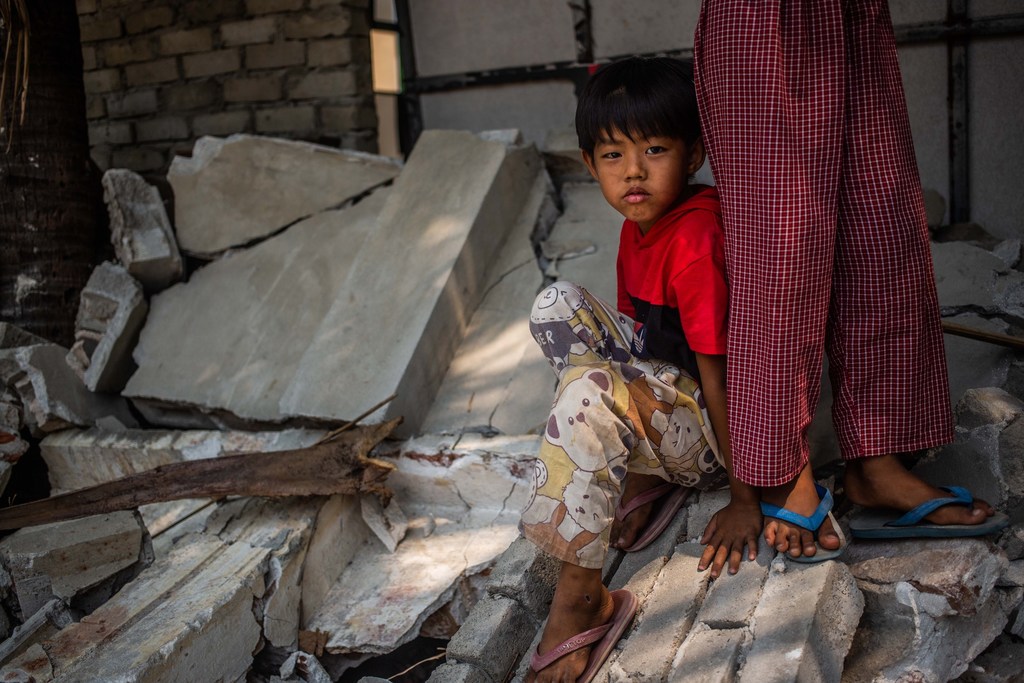 Un niño pequeño se sienta sobre los escombros de un edificio derrumbado en Mandalay, Myanmar, días después de un terremoto.