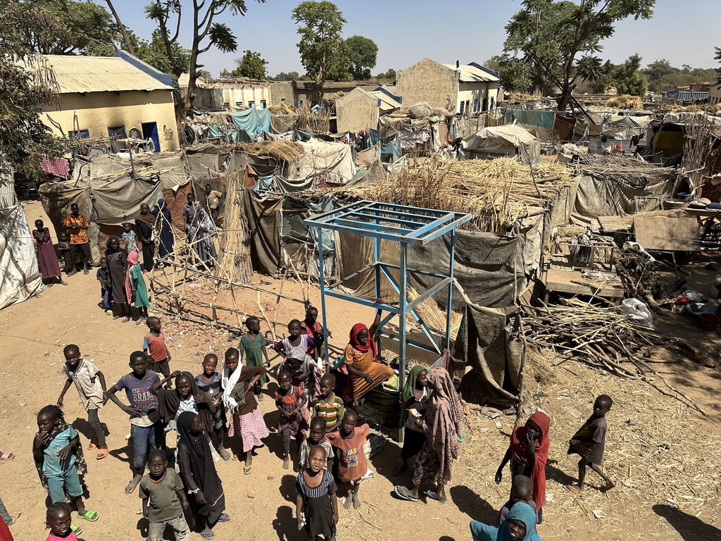 Des enfants et leurs familles près d'abris temporaires dans un camp de déplacés de la ville de Zelingei, au Darfour central, au Soudan.
