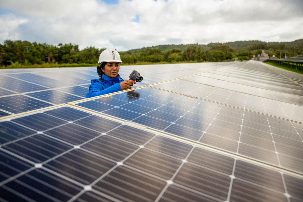 Una mujer trabaja en una granja de energía solar en Mauricio.