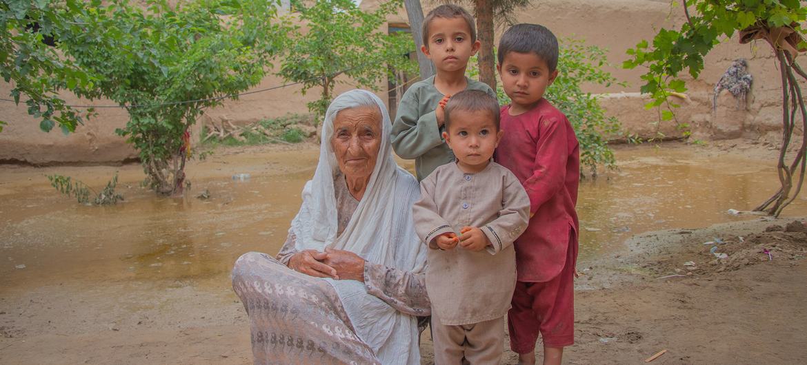 Uma avó se senta com seus três netos que ficaram feridos quando inundações repentinas atingiram seu vilarejo na província de Baghlan, no Afeganistão.