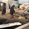 Women stand in a damaged displacement settlement in Khan Younis, Gaza.