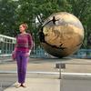 A cientista brasileira Natália Pasternak está ao lado de uma grande escultura de um globo dourado em Nova York.