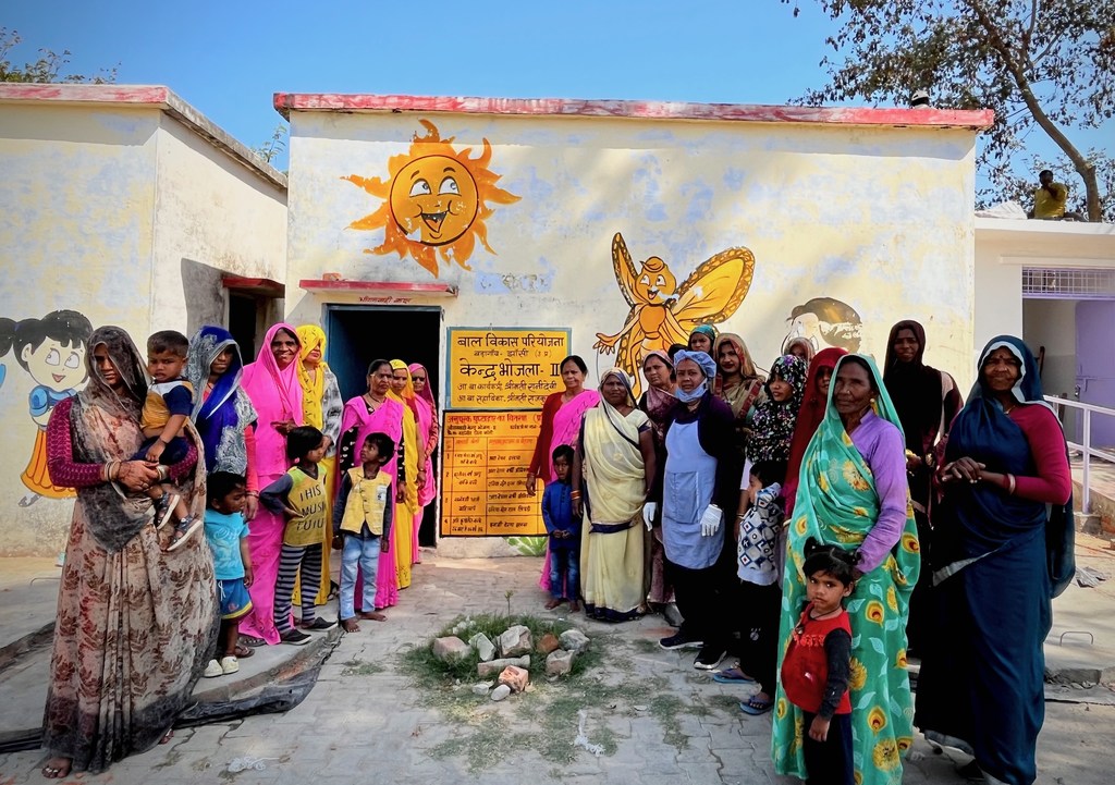 भारत में WFP के लाभार्थी, जिनमें महिलाएं और बच्चे भी शामिल हैं, टेक होम राशन योजना के लिए एक सामुदायिक केंद्र में एकत्रित हुए हैं।