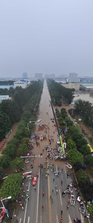 河北涿州一条被大水淹没的街道，救援人员正在使用冲锋舟进行救援。