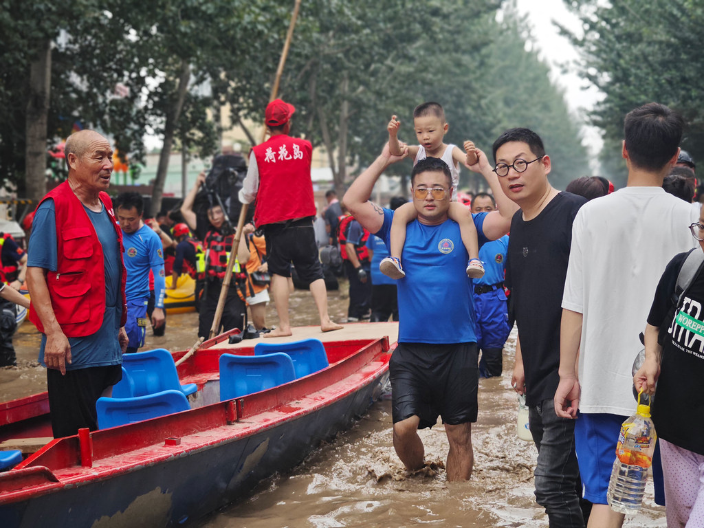 Los equipos de rescate transportan a personas asediadas por las inundaciones en Zhuozhou, provincia de Hebei en China.