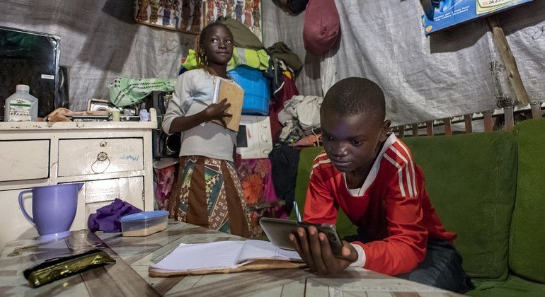 Брат и сестра в Кении делают уроки при помощи доступа в интернет на телефоне. В ООН хотят, чтобы к 2030 году доступ к цифровым сетям был у каждого