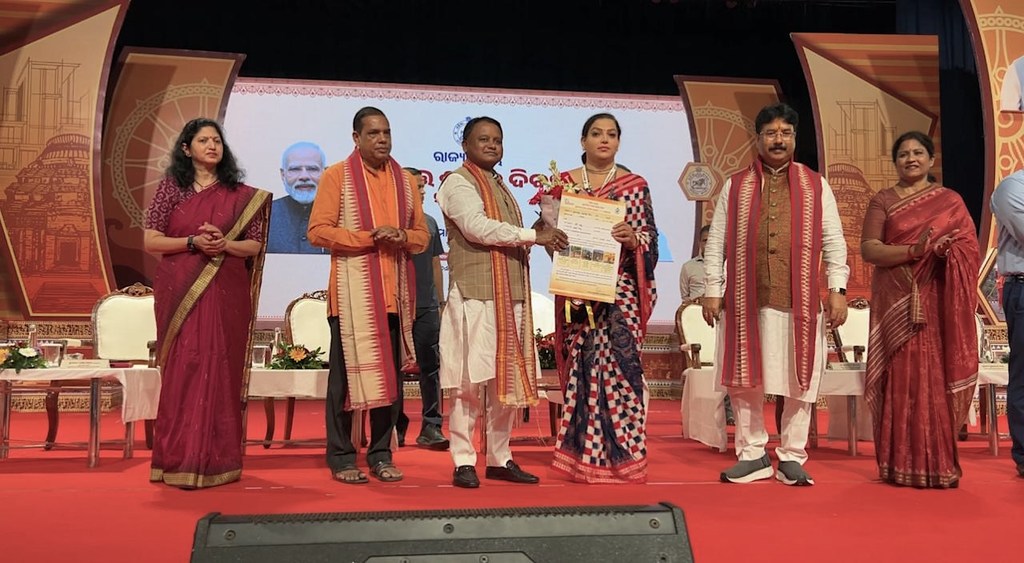 भारत में एक कार्यक्रम में मंच पर साड़ी पहने एक महिला को प्रमाण पत्र प्राप्त हुआ।