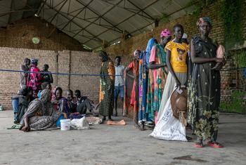दक्षिण सूडान के मालाकल में एक खाद्य वितरण केन्द्र पर लोग प्रतीक्षा कर रहे हैं.
