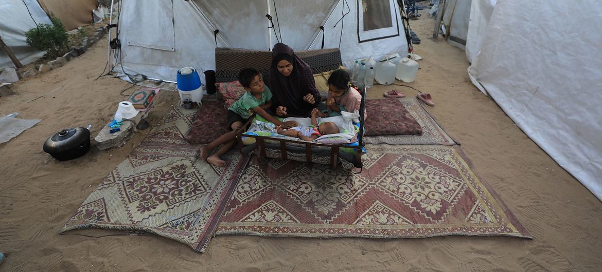 Une femme et ses trois enfants, dont un bébé de deux mois, dans un camp pour personnes déplacées à l'ouest de Gaza.