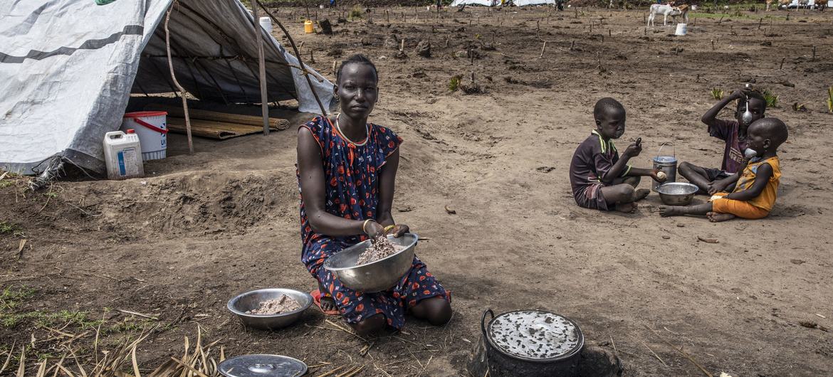दक्षिण सूडान के यूनिटी प्रान्त में एक महिला, विश्व खाद्य कार्यक्रम से प्राप्त सामग्री से खाना पका रही है.