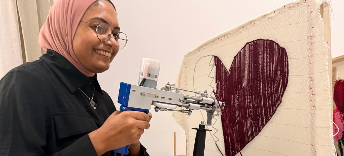 A woman uses a tufting machine to make a rug at the the Al-Thumama complex.