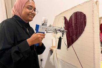 A woman uses a tufting machine to make a rug at the the Al-Thumama complex.