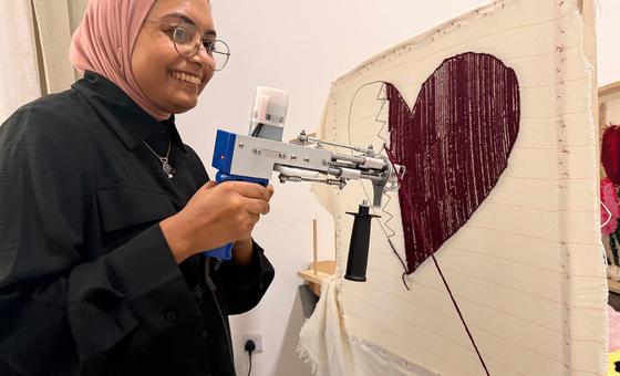 A woman uses a tufting machine to make a rug at the the Al-Thumama complex.