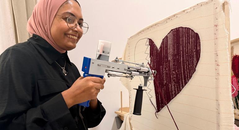 Une femme utilise une machine pour fabriquer un tapis dans le complexe Al-Thumama, au Qatar.