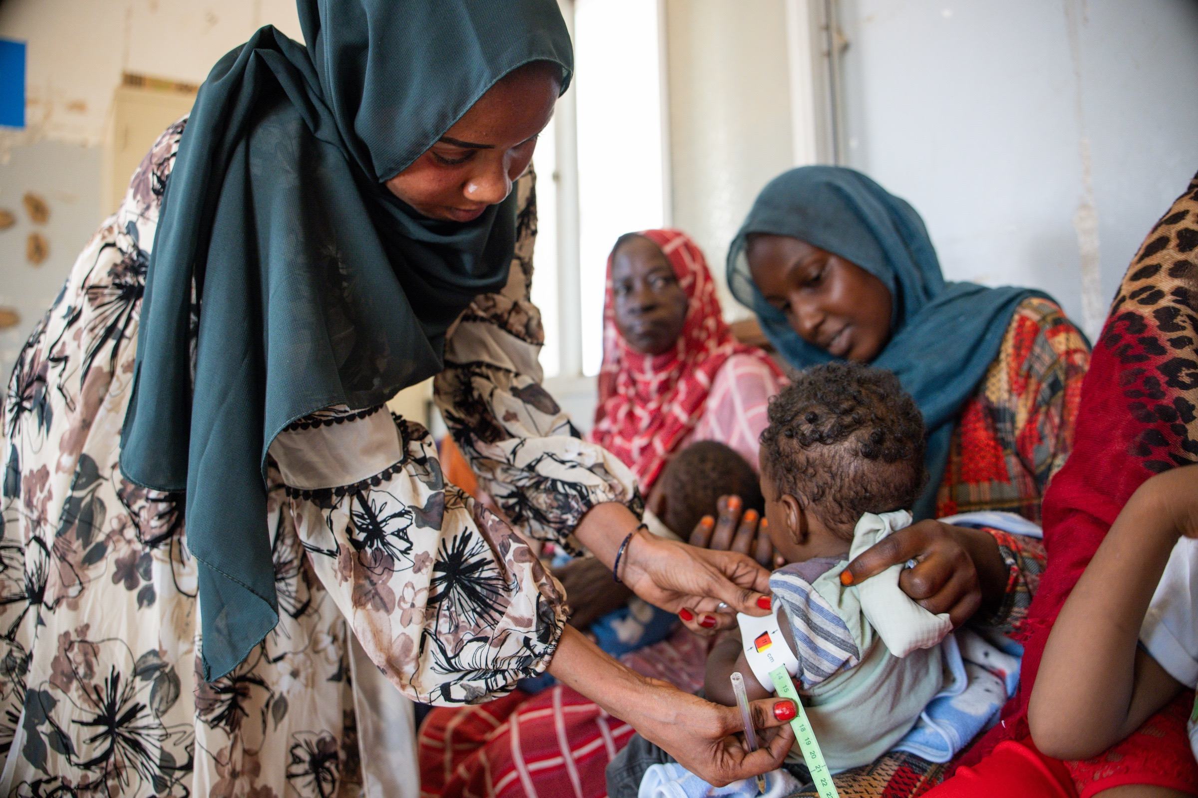 À Khartoum, au Soudan, un agent de santé examine un enfant afin de déceler des signes de malnutrition aigüe. Partout dans le monde, les conflits et les chocs climatiques alimentent la faim.