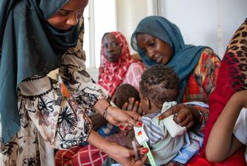 A health worker measures a child for signs of malnutrition in Khartoum, Sudan. Around the world, conflicts and climate-related shocks are driving rising hunger, leaving families struggling to access food, care and stability.