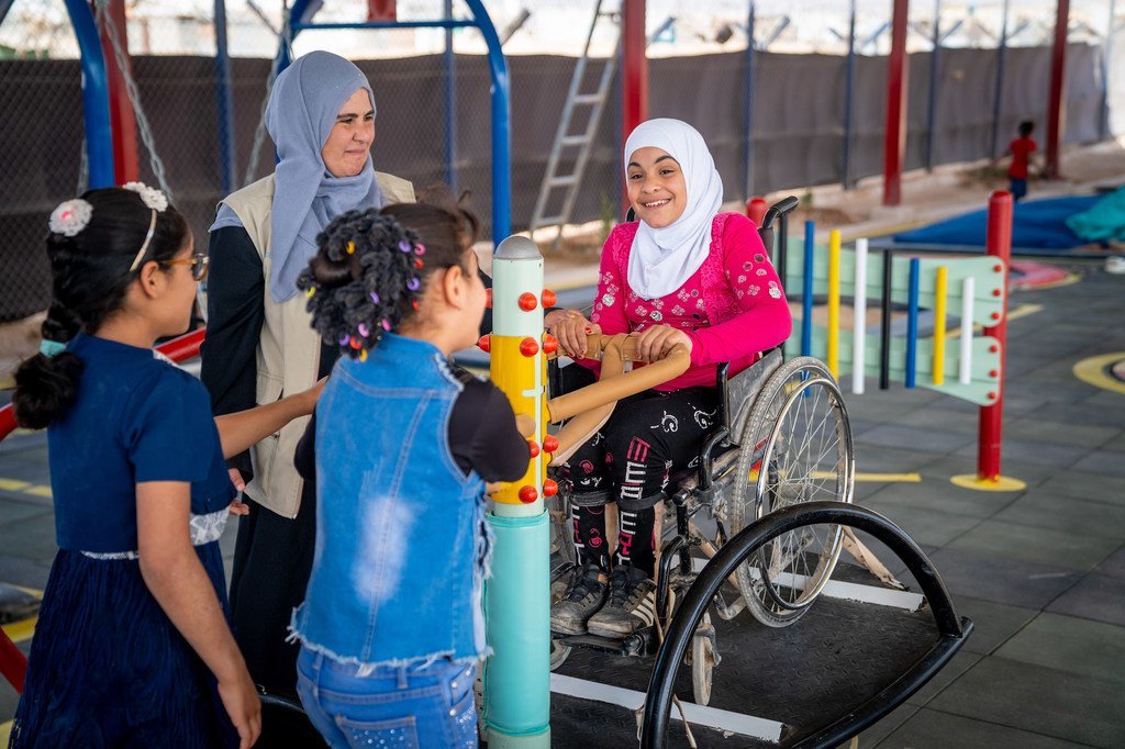 Une enfant de neuf ans joue à la balançoire avec ses amis dans une cour de récréation de son école au camp de réfugiés de Za'atari, en Jordanie.