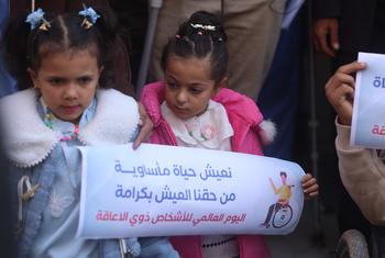 أطفال فلسطينيون تعرضوا لبتر في الأطراف بسبب إصابات في الحرب في غزة-  يحملون لافتات في فعالية بمناسبة اليوم الدولي للأشخاص ذوي الإعاقة