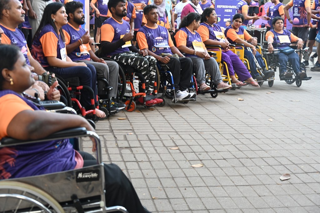 भारत में आयोजित पर्पल फेस्ट 2025 में मैराथन दौड़ के लिए व्हीलचेयर पर बैठे प्रतिभागी कतार में खड़े हैं।