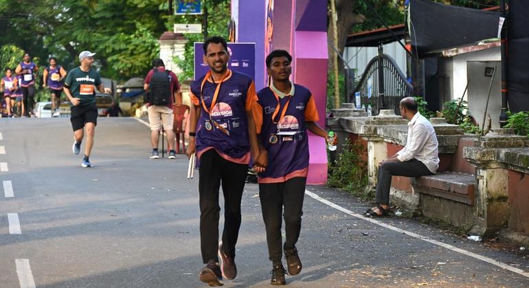 मैराथन में मार्गदर्शक के साथ भाग लेता एक दृष्टिबाधित प्रतिभागी.