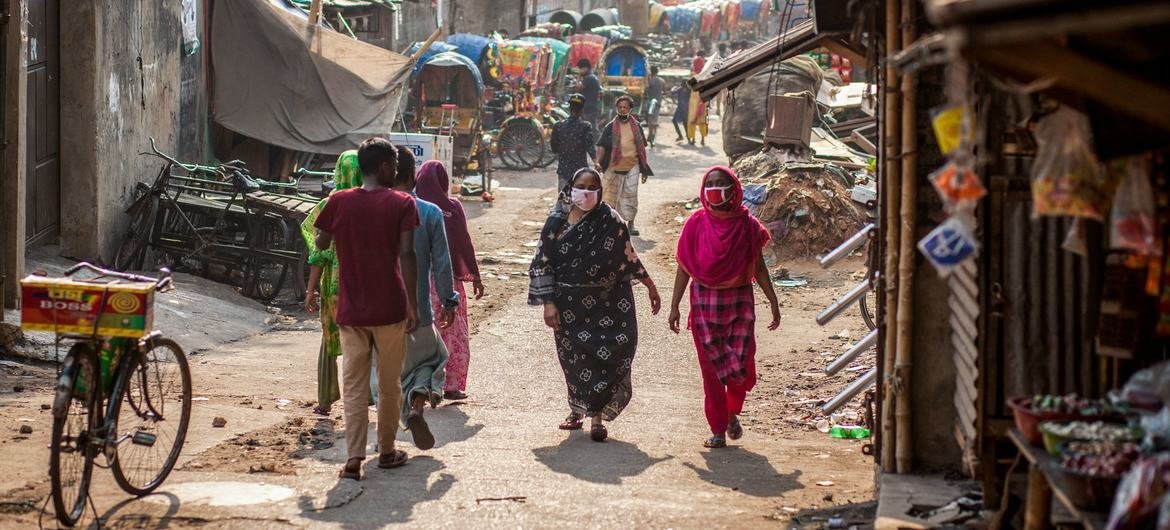 Mujeres con las máscaras por la pandemia de Covid 19 caminando por un mercado de Dhaka.