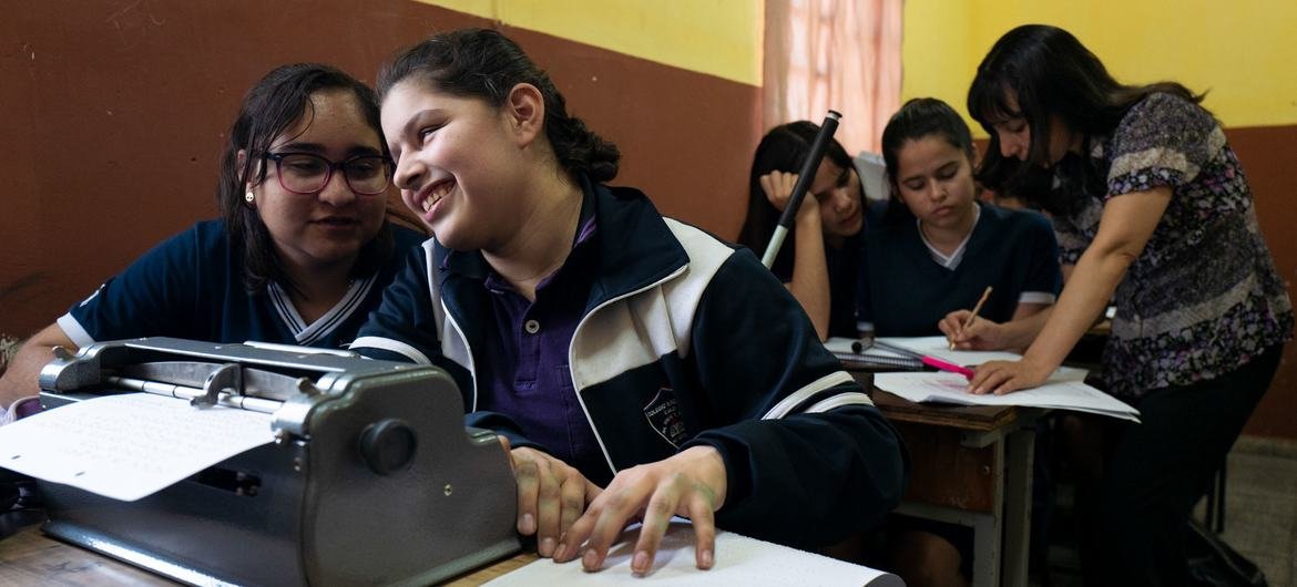Alina em sala de aula no Paraguai, aprendendo a ler e escrever em braile