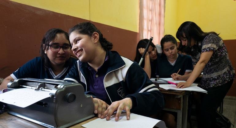 Alina em sala de aula no Paraguai, aprendendo a ler e escrever em braile
