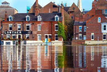 Una calle inundada con reflejos de edificios de ladrillo, incluido el pub Lowther, en York, Reino Unido.