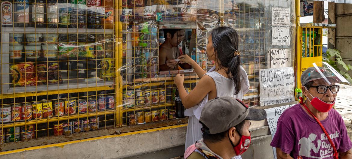 2021年9月16日，在菲律宾卡维特省巴科尔，一名女子在沿海村庄塔拉巴多斯村的售货亭购买商品。