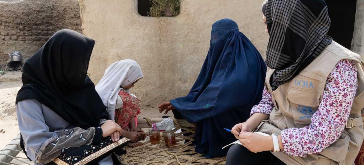 Un miembro del personal de la Oficina de Coordinación de Ayuda Humanitaria de la ONU habla con mujeres desplazadas en la provincia oriental de Nangahar, en Afganistán.