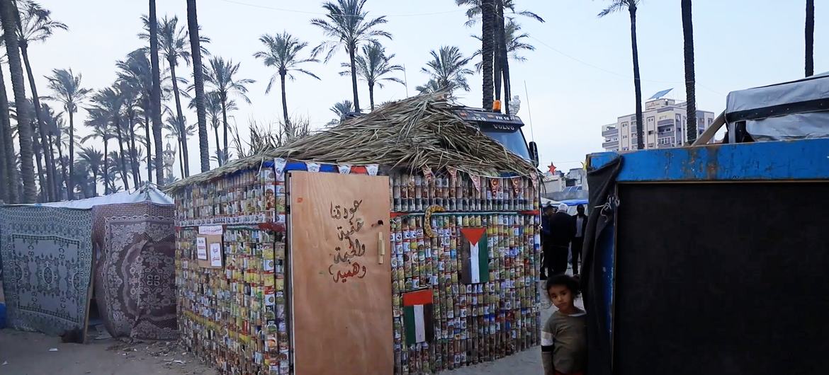 A tent built with canned food cans in the middle of a makeshift shelter in Deir Al-Balah, Gaza.