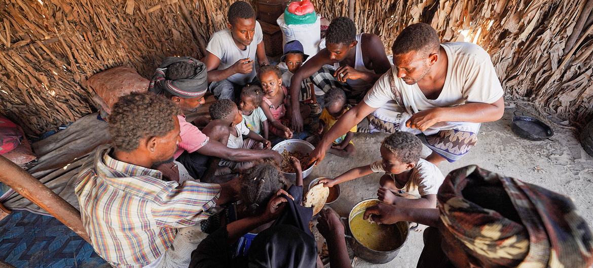 यमन में विश्व खाद्य कार्यक्रम से सहायता प्राप्त एक परिवार भोजन करते हुए.