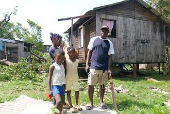 Une famille se tient devant sa maison endommagée par l'ouragan Beryl à St. Andrews, Grenade.