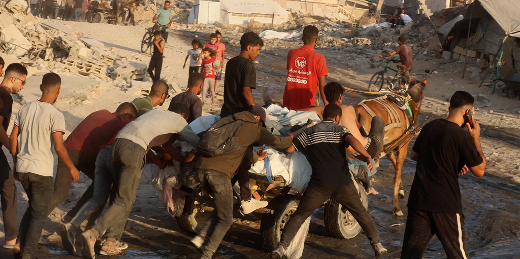 Una carreta carga los cuerpos de más de siete palestinos muertos mientras intentaban obtener comida.