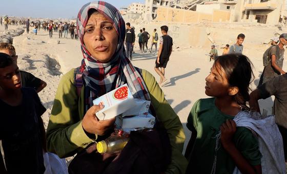 A Gazan woman holds precious food items she has managed to receive from an aid truck.
