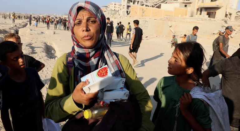 A Gazan woman holds precious food items she has managed to receive from an aid truck.