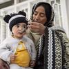 Uma agente comunitária de saúde alimenta uma criança pequena em uma área rural de Gilgit-Baltistão, no Paquistão.