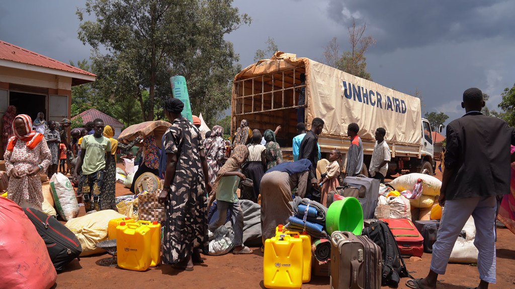 Wasudan wanaowasili wakishusha mizigo yao kutoka kwa lori katika kituo cha mapokezi kaskazini magharibi mwa Uganda.