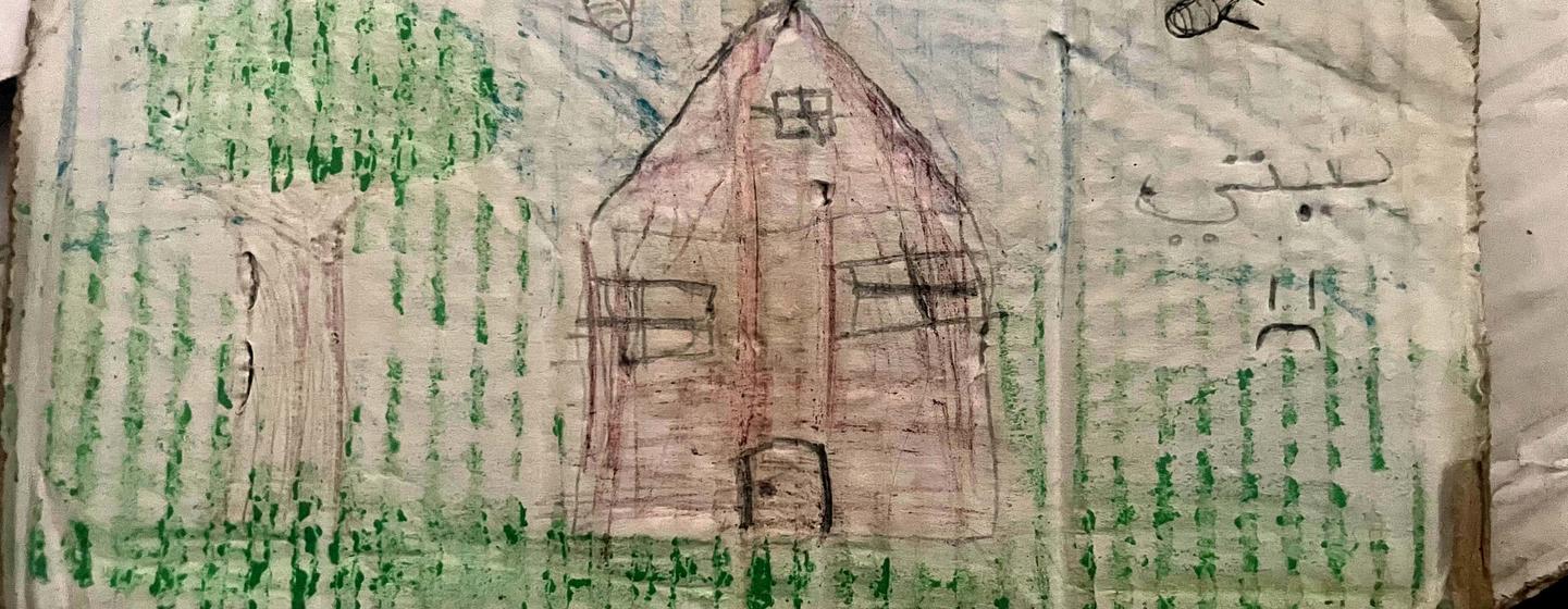 Un dessin d'enfant représentant une maison sur un morceau de carton, avec les mots « Ma maison » écrits en arabe.
