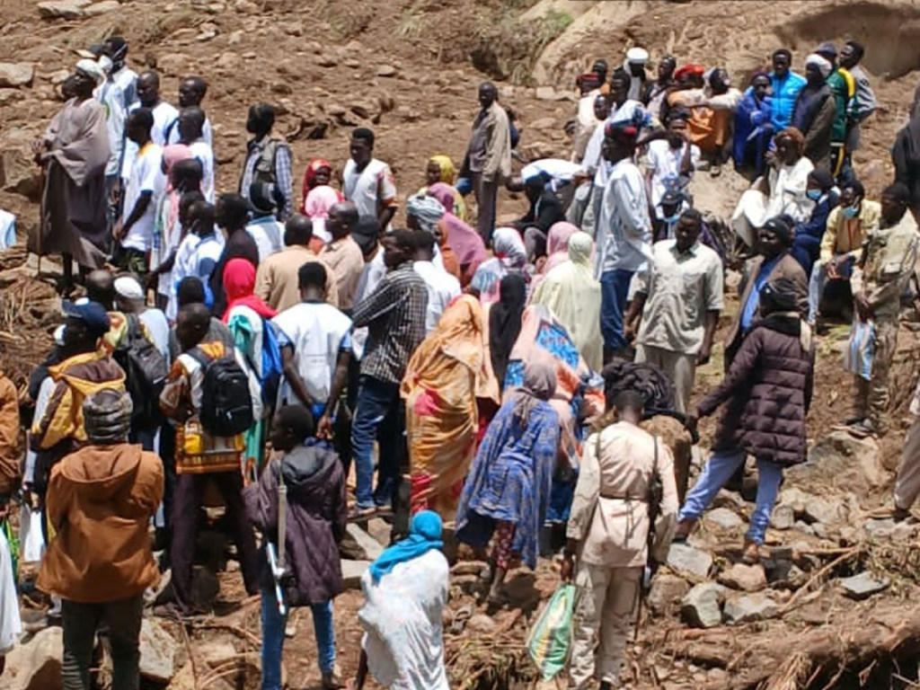 أناس يعاينون الدمار الذي سببه انهيار أرضي في قرية تارسين في جنوب دارفور بالسودان.