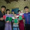 أفراد عائلة- عديمة الجنسية سابقا- يعرضون وثائق الهوية التي حصلوا عليها حديثا في منزلهم في دوشانبي، طاجيكستان.