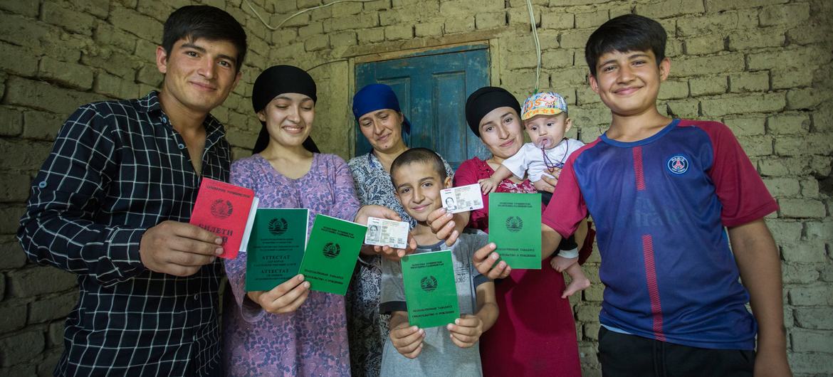 在塔吉克斯坦杜尚别，一户以前没有国籍的家庭正在展示他们新获得的身份证件。
