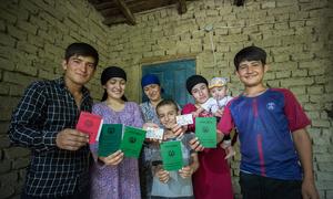 A formerly stateless family display their newly-obtained identity documents at their home in Dushanbe, Tajikistan. 