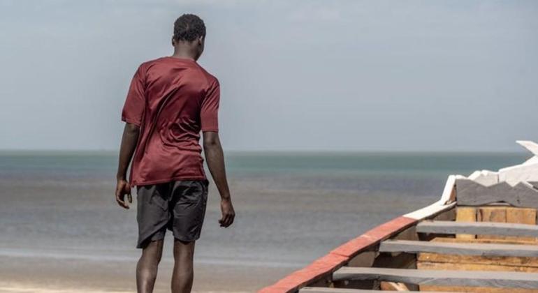 Kijana akitembea juu ya mashua karibu na pwani ya Gambia, eneo ambako mamia ya wahamiaji huanza safari zisizo na uhakika kuvuka bahari kila mwaka.