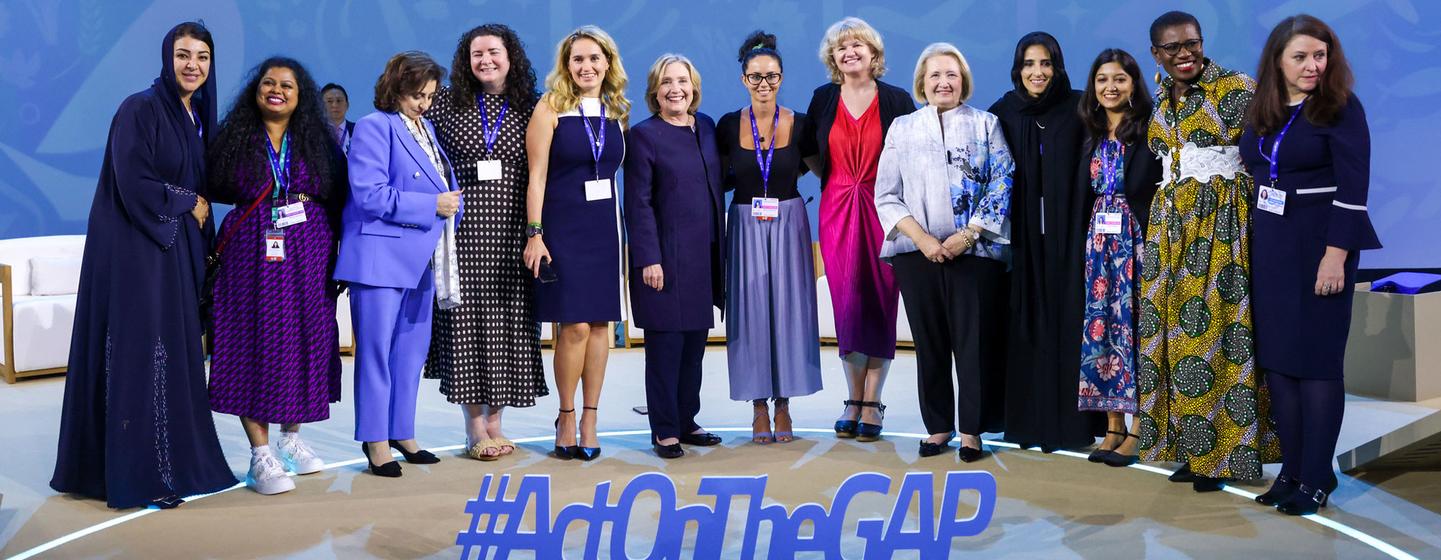 Hillary Clinton (centre) and other panelists pose together following a discussion on gender and climate.