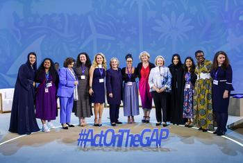 Hillary Clinton (centre) and other panelists pose together following a discussion on gender and climate.